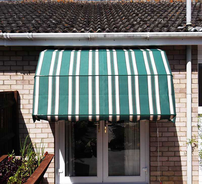 Green striped canopy installed above french doors.
